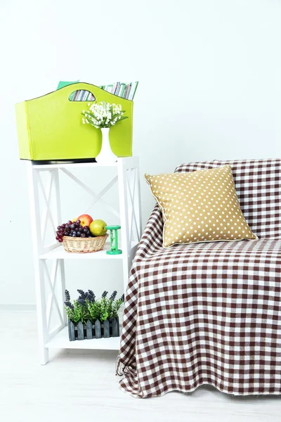 Magazines and folders in green box on shelf in room