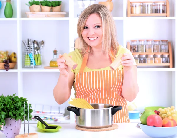 Happy smiling woman in kitchen preparing for healthy meal