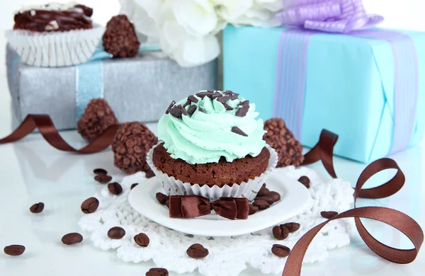 Tasty cupcake with gifts close up