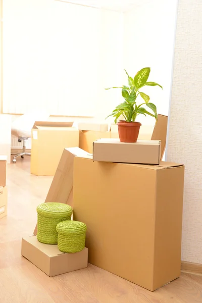 Empty room with stack of cartons: moving house concept