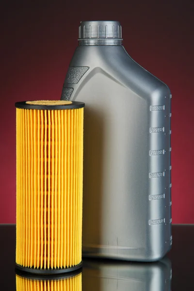 Car oil filter and motor oil can on dark color background