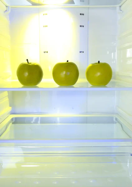 Apples in open empty refrigerator. Weight loss diet concept.
