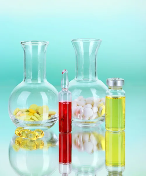 Medical bottles and pills on green background