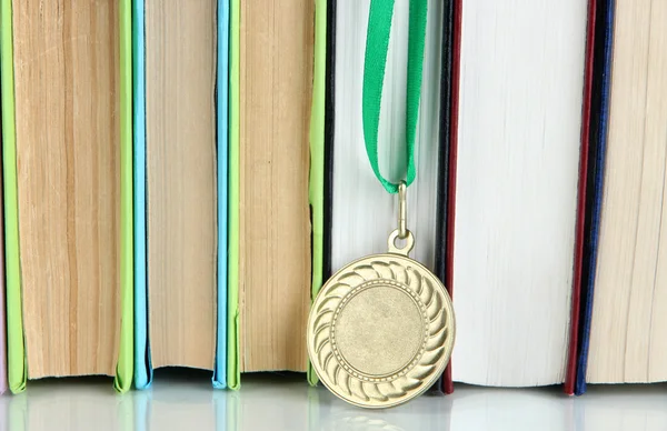 Medal for achievement in education with books close up