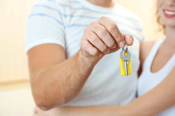 Young couple with keys to your new home close-up