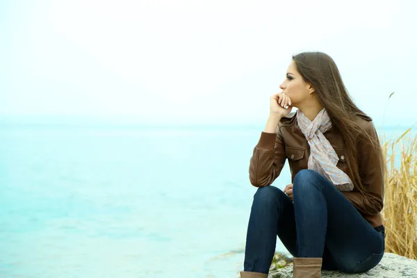 Portrait of young serious woman near river