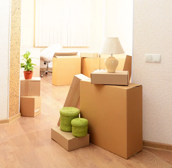 Empty room with stack of cartons: moving house concept