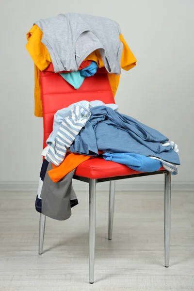 Heap of clothes on color chair
