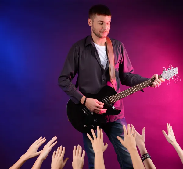 Guitarist singing on stage at a rock concert for his adoring fans