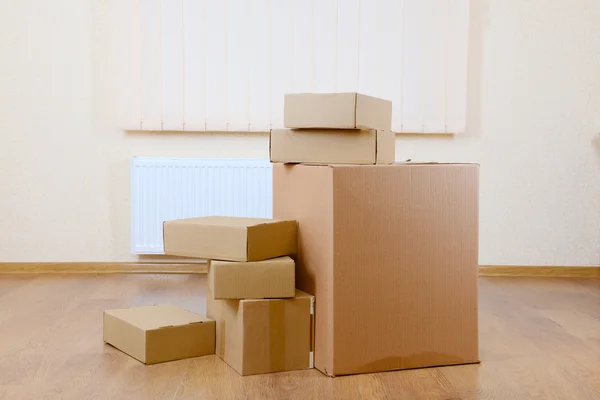 Empty room with stack of cartons: moving house concept