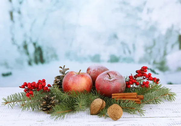 Christmas composition with red winter apples on bright background