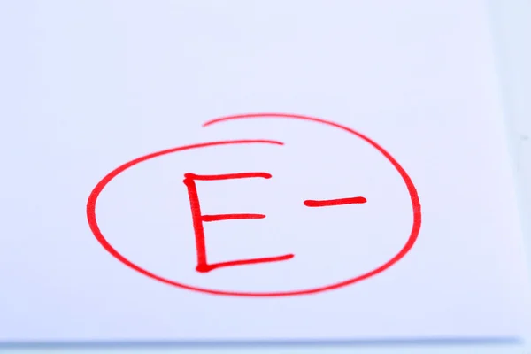 Grade E- written on an exam paper