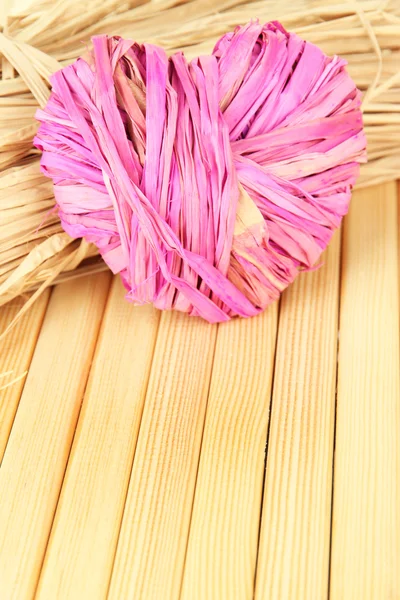 Decorative straw for hand made and heart of straw, on wooden background