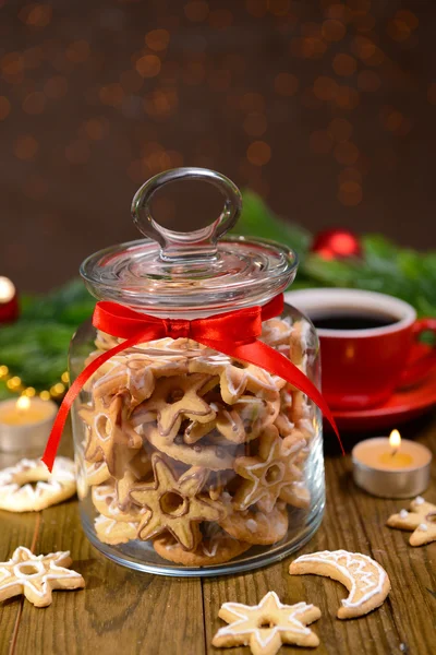 Delicious Christmas cookies in jar on table on brown background