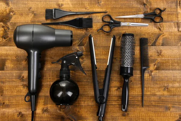 Hairdressing tools on wooden table close-up