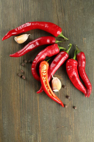 Red hot chili peppers and garlic, on wooden background