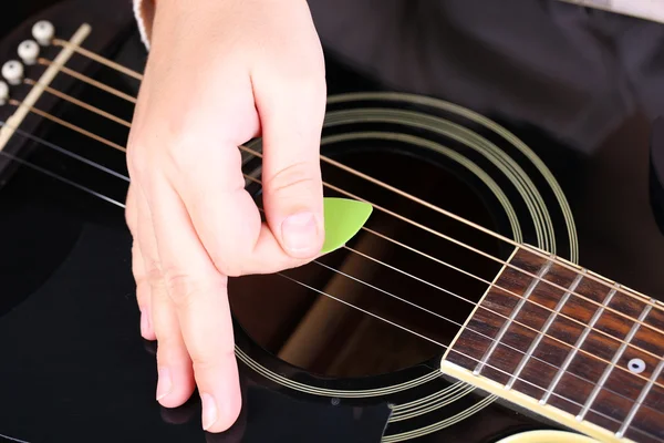 Acoustic guitar in female hands, close-up