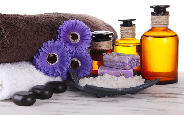 Beautiful spa setting with flowers on wooden table on bright background