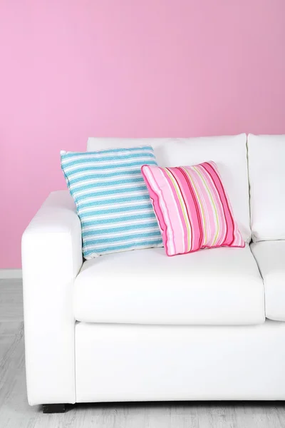 White sofa close-up in room on pink background