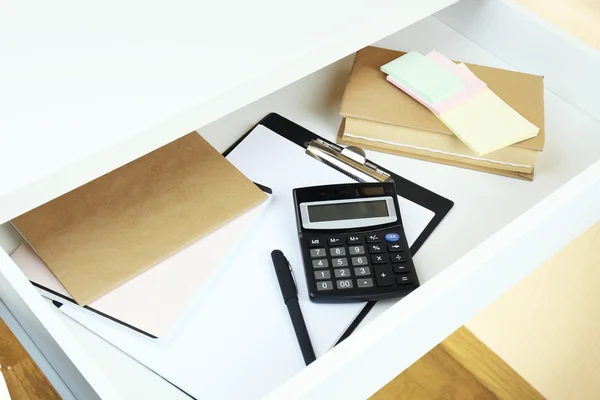 Office supplies in open desk drawer close up