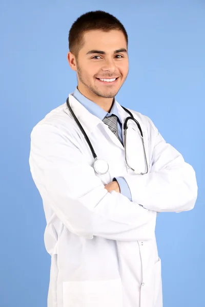 Male Doctor standing with folder, on blue background