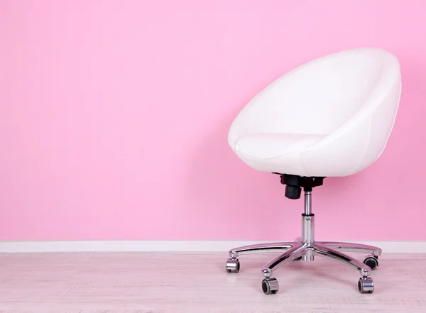 Modern chair in room on pink background