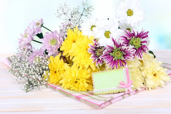 Beautiful chrysanthemum flowers on table on light background