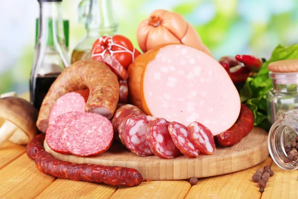 Different sausages on wooden table on natural background