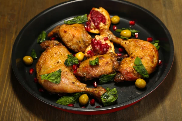 Homemade fried chicken drumsticks with vegetables on pan, on wooden background