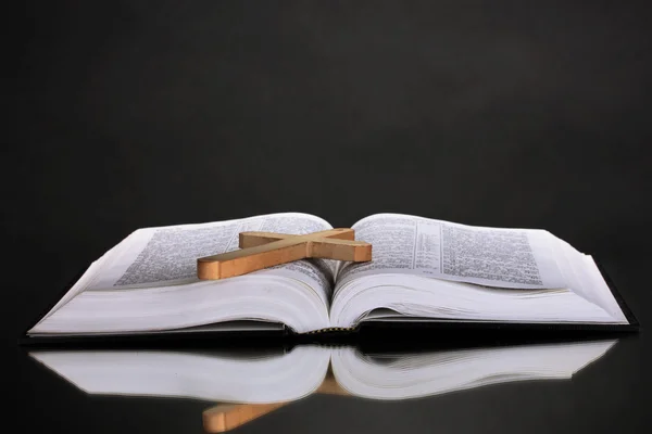 Russian bible and wooden cross on black background