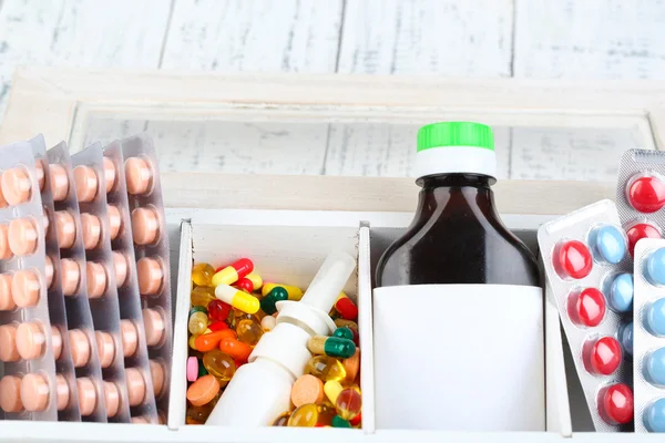 Medical pills, ampules in wooden box, close-up