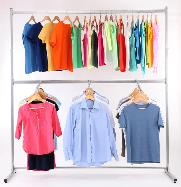Different clothes on hangers, on gray background