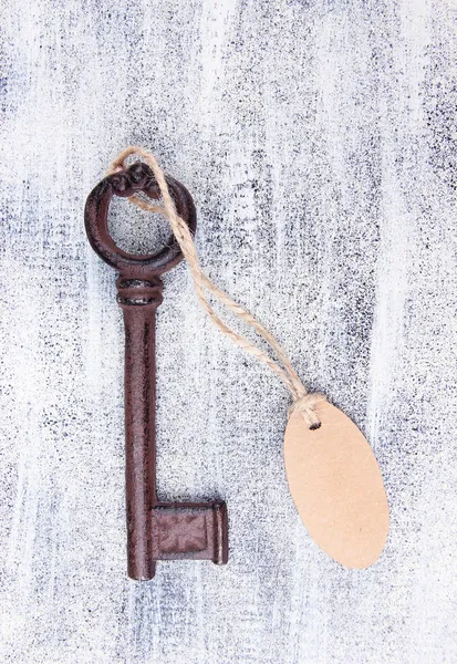 Key with empty tag, on color wooden background