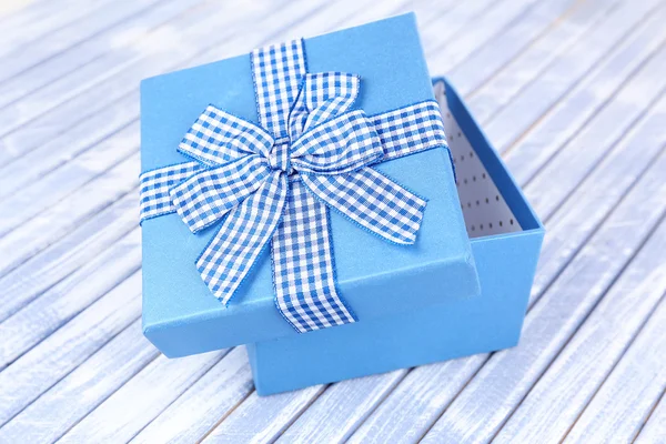 Open gift box on wooden background