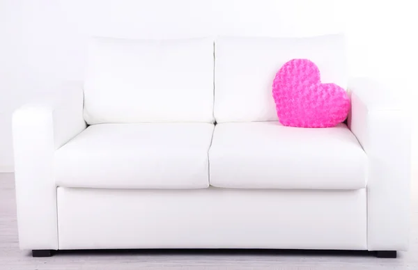 Pink heart shaped pillow on white sofa