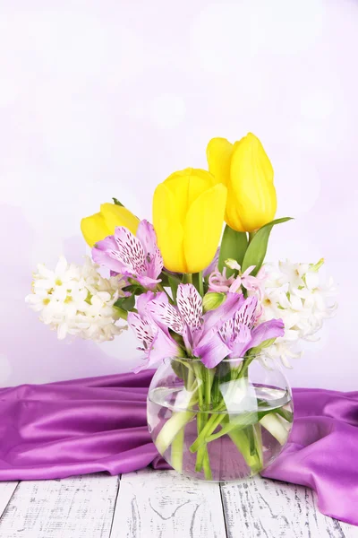 Flowers in vase on table on bright background