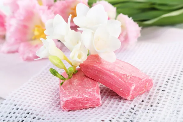 Composition with beautiful  flowers and soap on wooden background