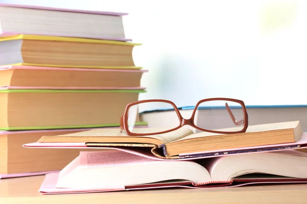 Composition with glasses and books, on table, on light background