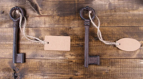 Keys with empty tag, on color wooden background