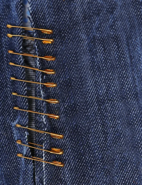 Safety pins on fabric background