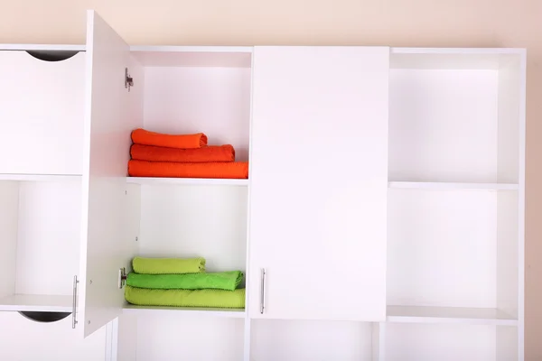 White shelves with colored towels close up