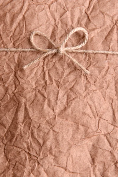 String tied in  bow on brown paper packaging close-up