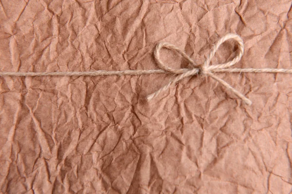 String tied in  bow on brown paper packaging close-up
