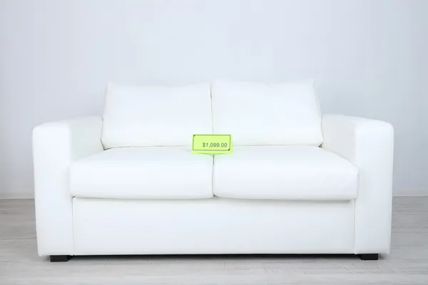 New white sofa with price on light background