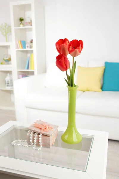 Beautiful spring flowers in vase on home interior background