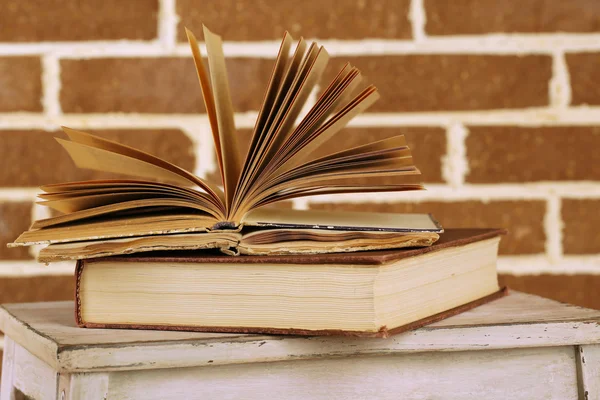 Books on wooden ladder on  color wall background