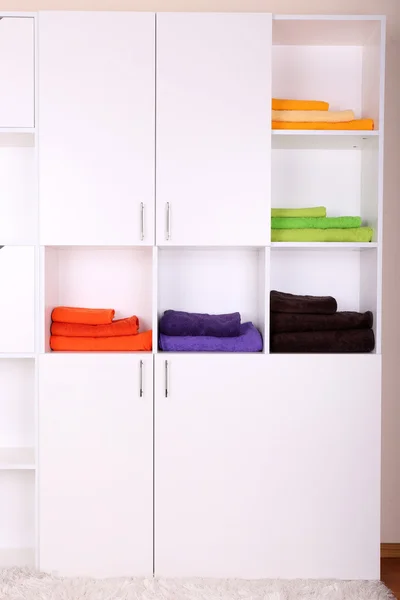 White shelves with colored towels close up
