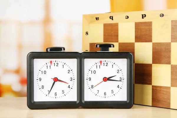 Chess clock and board on light background