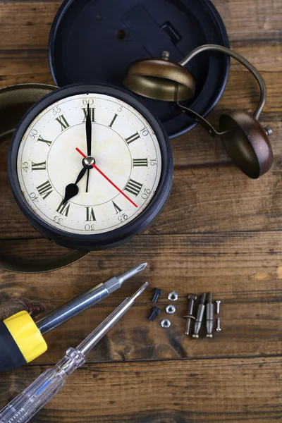 Repair clock on wooden background