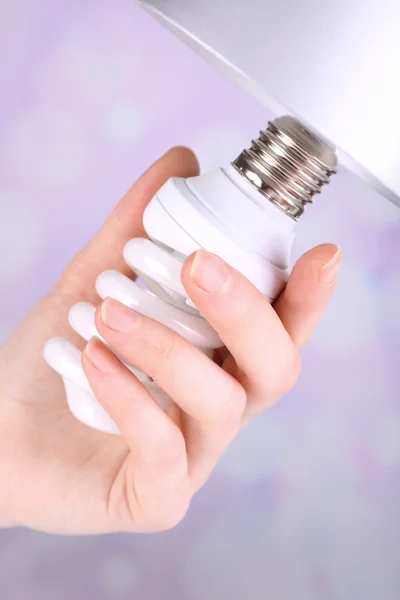Hand changing light bulb for lamp at home